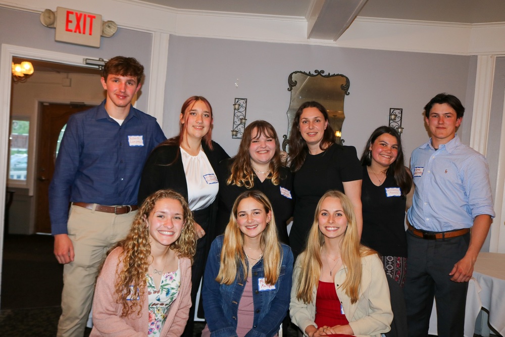 eight high school students standing with their teacher Mrs. Giarrusso at an awards ceremony