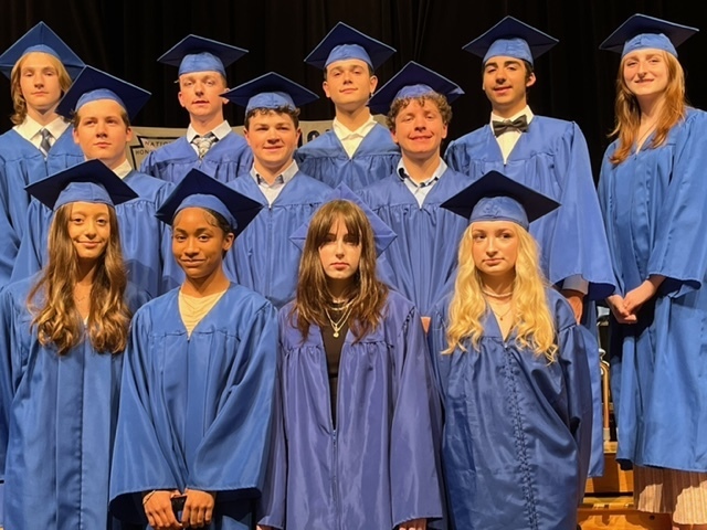 12 high school students wearing blue caps and gowns