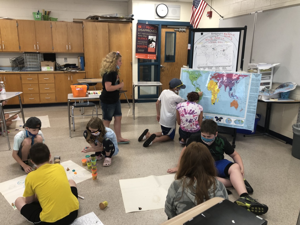 middle school students in a classroom looking at and creating maps