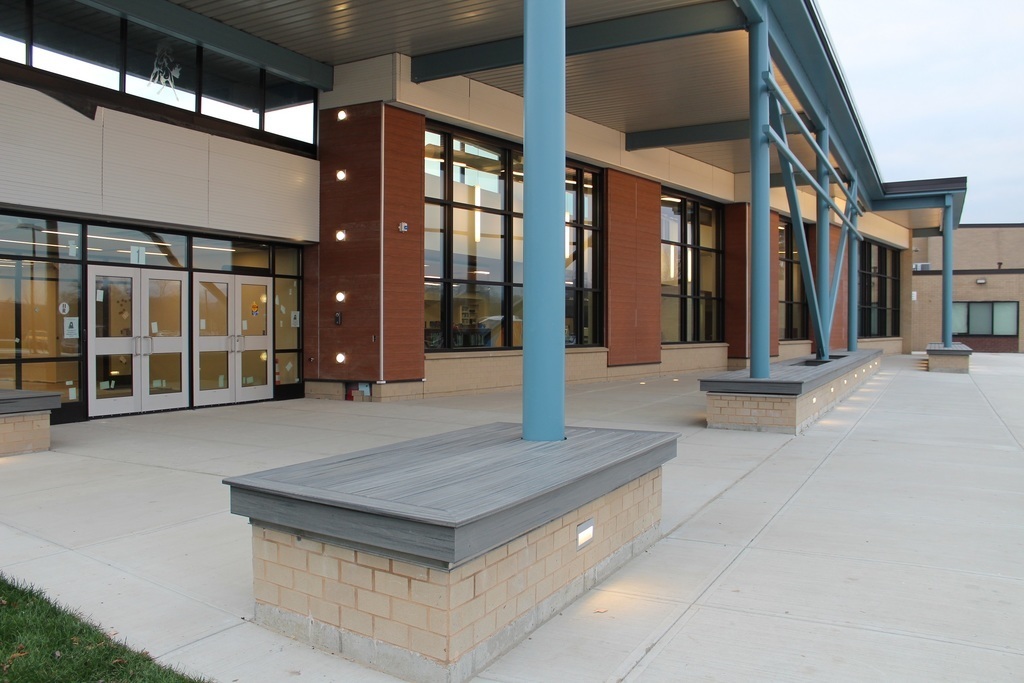 benches and posts under the overhang at the high school entrance sidewalk