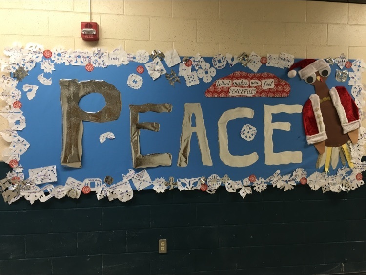 A board reading PEACE that has snowflakes on it