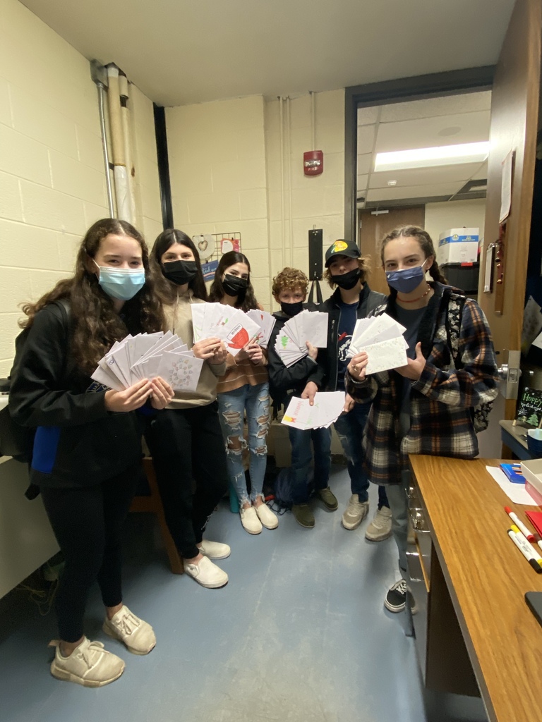 six high school students wearing masks and holding lots of white envelopes
