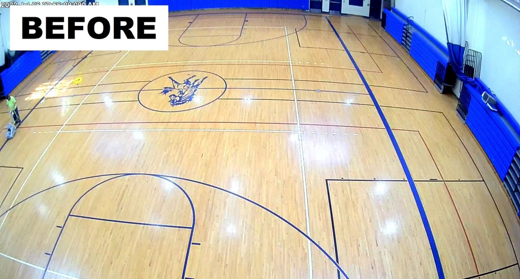 old gym floor with small blue mustang mascot logo in center court