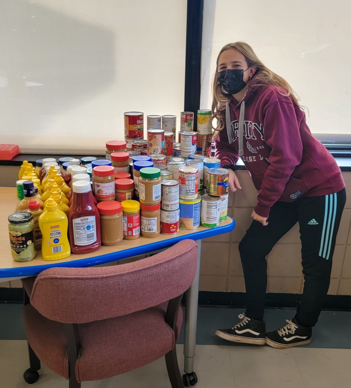 Mckayla Mudge stands with donated food items
